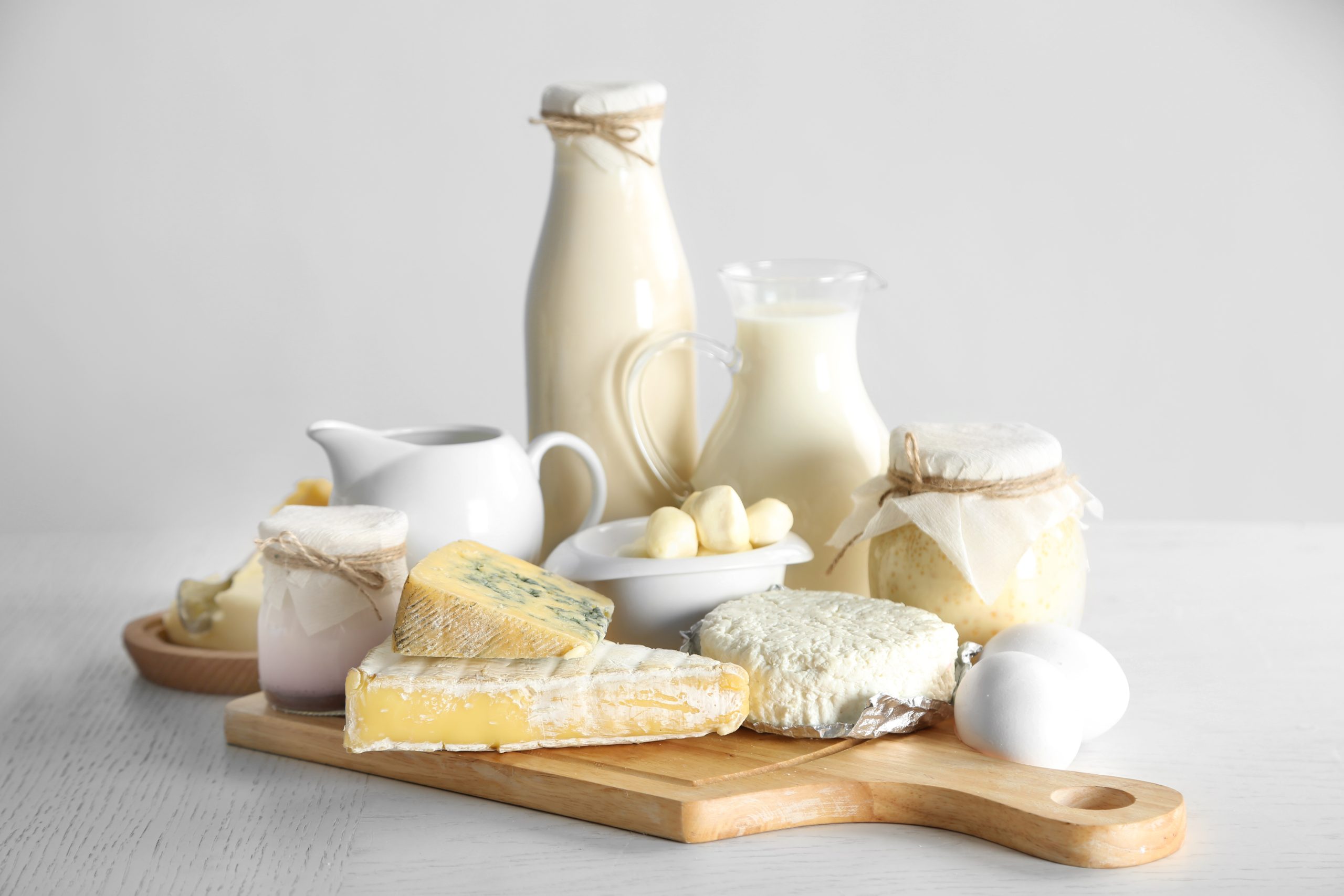 set of fresh dairy products on wooden table, on white background